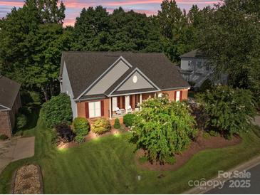 Beautiful brick home featuring a well-manicured lawn and vibrant landscaping at 1525 Valhalla Dr, Denver, NC 28037