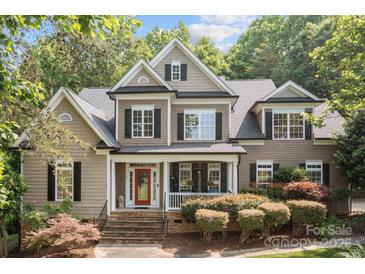 Charming two-story home featuring a red front door, manicured landscaping, and a welcoming front porch at 154 Hunters Hill Dr, Statesville, NC 28677