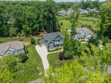 Stunning aerial view of a two-story home with a long driveway and lush green landscaping and mature trees at 208 South Shore Dr, Belmont, NC 28012