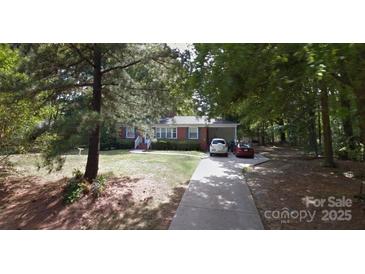 Charming single-story home with a long driveway, mature trees, and well-maintained front yard landscaping at 2930 Sheets Cir, Charlotte, NC 28214