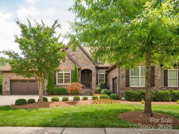 Charming stone home with manicured lawn and mature landscaping at 5805 Copperleaf Commons Ct, Charlotte, NC 28277