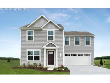 Charming two-story home with gray siding, a neatly manicured lawn, and an attached two-car garage at 12013 Beaux Art Ln, Charlotte, NC 28214