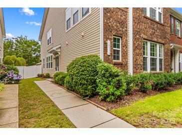 Charming exterior showcasing a well-maintained home with a combination of brick and siding, lush landscaping, and a welcoming walkway at 18339 The Commons Blvd, Cornelius, NC 28031