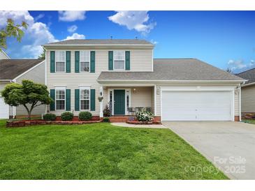 Charming two-story home with a well-manicured lawn, complemented by lush landscaping and a two-car garage at 2018 Rosewater Ln, Indian Trail, NC 28079