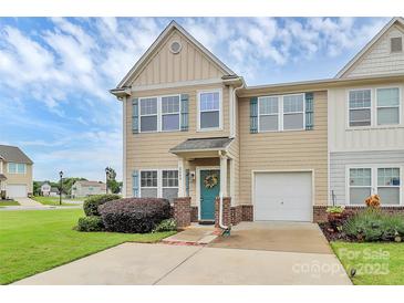 Charming tan townhouse with a teal front door and a well-manicured lawn and one-car garage at 2840 Hopeton Ct, Monroe, NC 28110