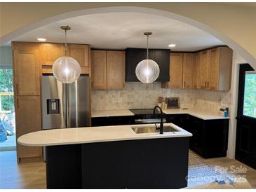 An open kitchen with modern appliances, a large island, and stylish pendant lighting is seen at 3326 Winterfield Pl, Charlotte, NC 28205
