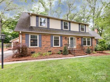 Charming two-story brick home with blue shutters and manicured lawn offering timeless appeal at 6941 Queensberry Dr, Charlotte, NC 28226