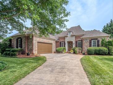 Charming brick and stone home featuring a lush lawn, decorative shutters and a well-manicured front yard at 705 Woburn Abbey Dr, Fort Mill, SC 29715