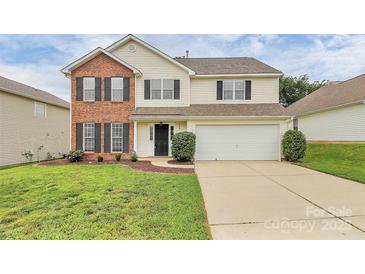 Charming two-story home featuring a brick facade, well-manicured lawn, and a two-car garage at 720 Reigate Rd, Charlotte, NC 28262