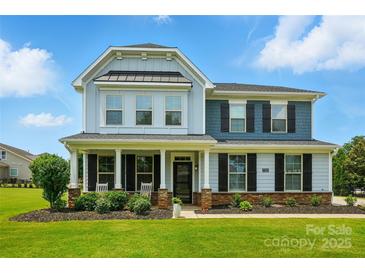 Charming two-story home features a covered front porch, manicured lawn, and craftsman details at 7322 Vesper Dr, Huntersville, NC 28078