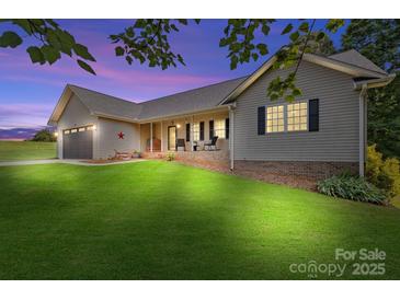 Charming home with lush green lawn, inviting front porch, and a two-car garage offers curb appeal at 105 Saddlewood Ln, Statesville, NC 28625