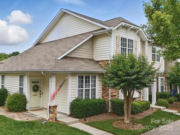 Charming townhome featuring stone accents, a welcoming front door, and a well-maintained lawn and landscaping at 1061 Woodglen Ln, Matthews, NC 28104