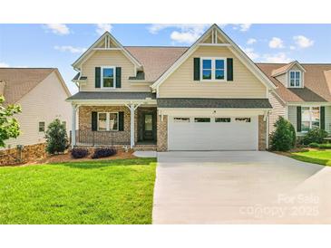 Charming two-story home with a well-manicured lawn, a brick porch, and an attached two-car garage at 1280 Winged Foot Dr, Denver, NC 28037