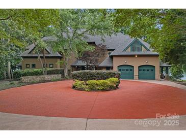 Stunning two-story home featuring a circular driveway, three-car garage and lush landscaping at 145 Hunters Pointe Ln, Mooresville, NC 28117