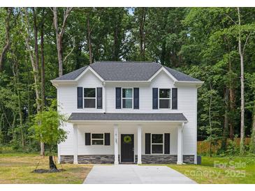 Charming two-story home featuring a welcoming front porch, black shutters, and a freshly landscaped yard at 1815 Wildwood Dr, Charlotte, NC 28214
