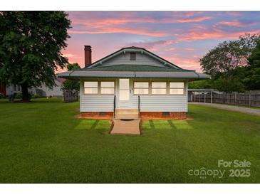 Charming home with a manicured lawn and picturesque sunset backdrop at 3345 Long Ferry Rd, Salisbury, NC 28146