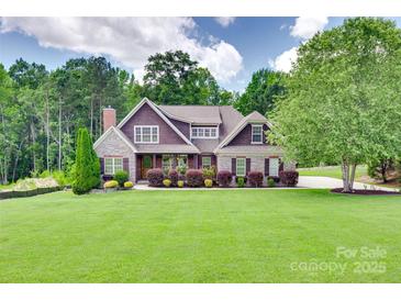 Charming two-story home with manicured lawn, mature trees, and stone accents at 5164 Mill Race Ln, Lancaster, SC 29720