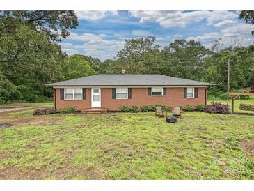 Charming brick home featuring a well-maintained yard and a cozy firepit area for outdoor enjoyment at 5222 Sikes Mill Rd, Monroe, NC 28110