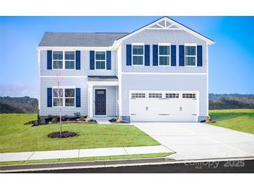 Charming two-story home featuring blue accents, a two-car garage, and a well-maintained front lawn at 12109 Beaux Art Ln, Charlotte, NC 28214