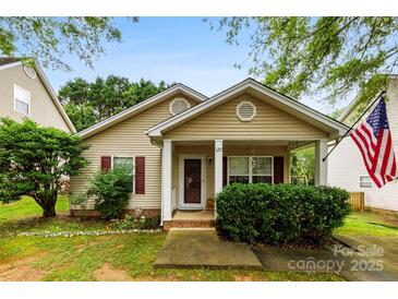 Charming single-story home with manicured lawn, covered porch, and classic architectural details under a clear blue sky at 122 Pratt St, Belmont, NC 28012