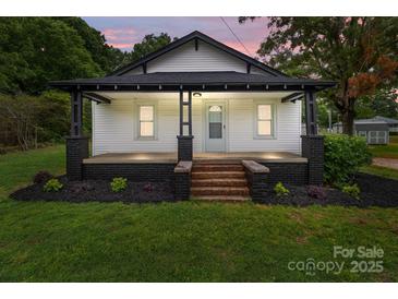 Charming home featuring a cozy front porch with updated landscaping at 1406 Upper Enochville Rd, Kannapolis, NC 28081