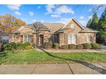 Charming brick home featuring manicured landscaping, symmetrical design, and a welcoming front entrance at 14700 Old Vermillion Dr, Huntersville, NC 28078