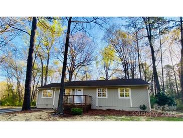 Charming single-story home with a welcoming front porch nestled among mature trees and a 'For Sale' sign at 1583 Green Circle Dr, Gastonia, NC 28054