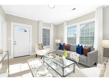 Bright living room with large windows, modern gray couch and stylish decor at 210 E 5Th Ave, Gastonia, NC 28054