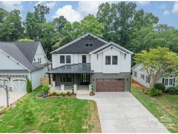 Beautiful new construction home boasts lush green lawn and two car garage at 2412 Kingsbury Dr, Charlotte, NC 28205