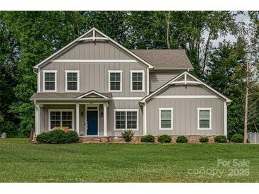 Charming two-story home with a well-manicured lawn and inviting blue front door at 360 Sundown Rd, Mooresville, NC 28117