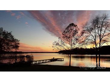 Scenic lake view at sunset with a long dock and colorful sky, perfect for relaxing or entertaining at 4574 Ivy Run Ln, Denver, NC 28037