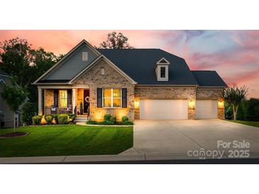 Charming brick home featuring a well-manicured lawn, inviting front porch, and a spacious three-car garage at 7026 Wyngate Pl, Lancaster, SC 29720
