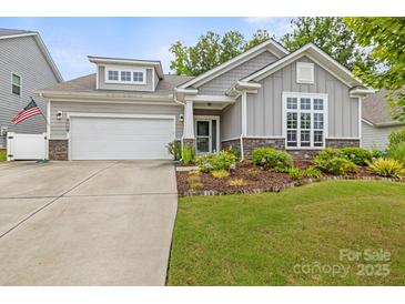 Charming home featuring gray siding, stone accents, well-manicured lawn, and a two-car garage at 219 Broadleaf Dr, Denver, NC 28037