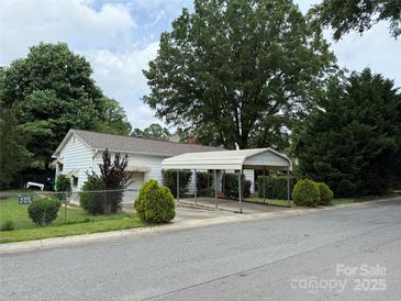 Charming home featuring a carport and a well-maintained front yard with mature trees at 3500 Blessing St, Charlotte, NC 28208