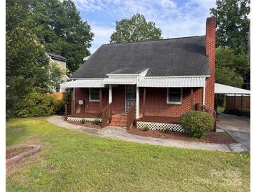 Charming brick home featuring a well-maintained lawn, a chimney, and awning-covered porches at 3726 The Plaza None, Charlotte, NC 28205