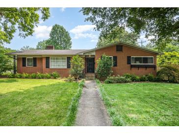Charming brick home with a well-manicured lawn and mature trees providing shade at 4044 Somerdale Ln, Charlotte, NC 28205