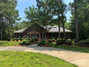 Charming single-story brick home with well-manicured landscaping and a circular driveway at 102 Rosewood Ln, Locust, NC 28097