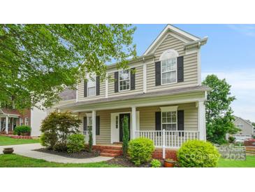 Charming two-story home featuring a welcoming front porch and beautifully landscaped front yard at 10306 Madison Park Dr, Charlotte, NC 28269