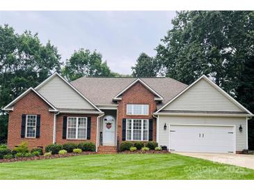 Charming brick home featuring a well-manicured lawn and an attached two-car garage at 104 Laura Ct, Cherryville, NC 28021