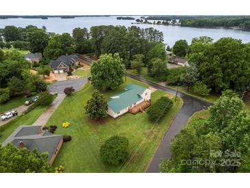 Expansive property with a charming home, lush green lawn, and stunning lake views at 105 Pelican Ct, Mooresville, NC 28117