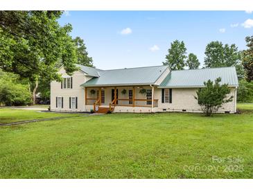 Charming home featuring a covered front porch, a manicured lawn, and beautiful landscaping at 105 Pelican Ct, Mooresville, NC 28117