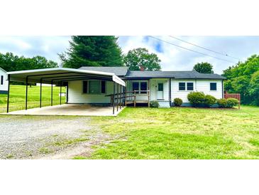 Ranch-style home with white siding, a covered carport, front porch, and mature trees in the front yard at 271 Nc 16 N Hwy, Taylorsville, NC 28681