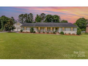 Charming one-story home with brick exterior, lush lawn, and a separate garage at 309 Ogden Dr, Gastonia, NC 28056