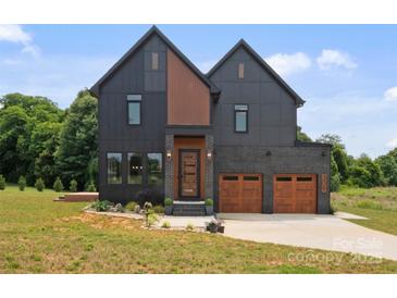 Contemporary two-story home features a two-car garage, modern siding and professional landscaping at 309 Sain Rd, Statesville, NC 28625