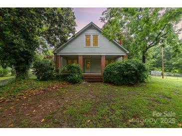 Charming two-story home with brick-columned front porch and lush landscaping at 520 Eastwood Park Cir, Albemarle, NC 28001