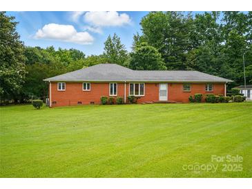 Charming single story brick home with a well-maintained lawn, mature trees, and a welcoming facade at 6900 Ridge Lane Rd, Charlotte, NC 28262