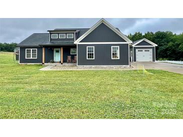 Charming home with dark siding, white trim, and a well-manicured lawn at 7133 Church Rd, Taylorsville, NC 28681