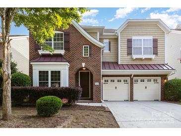 Charming two-story home featuring a two-car garage, brick facade, and meticulously landscaped front yard at 9429 Ridgeforest Dr, Charlotte, NC 28277