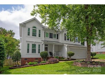 Charming two-story home boasts a manicured lawn and a classic white facade, creating a welcoming curb appeal at 10924 Owl Nest Ln, Charlotte, NC 28277