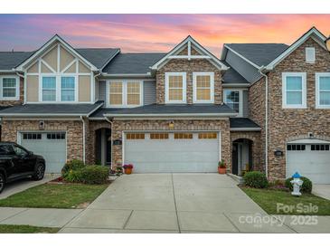 Charming townhouse featuring a stone facade, two-car garage, and well-maintained landscaping at 1126 Roderick Dr, Fort Mill, SC 29708
